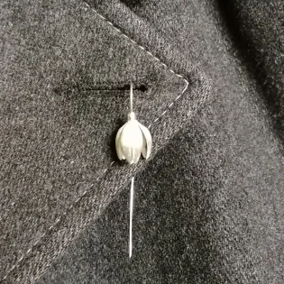 Silver Snowdrop flower Lapel Pin on grey coat