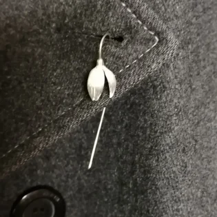 Silver Snowdrop Lapel Pin on a Grey Coat