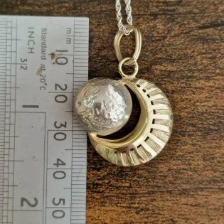 Moon Pendant Necklace next to ruler