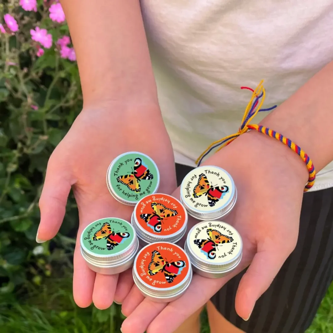 Collection of Mini Tin Thank You For Helping Me Grow Teachers Gift by Seedball available at Tiezori pictured on hands